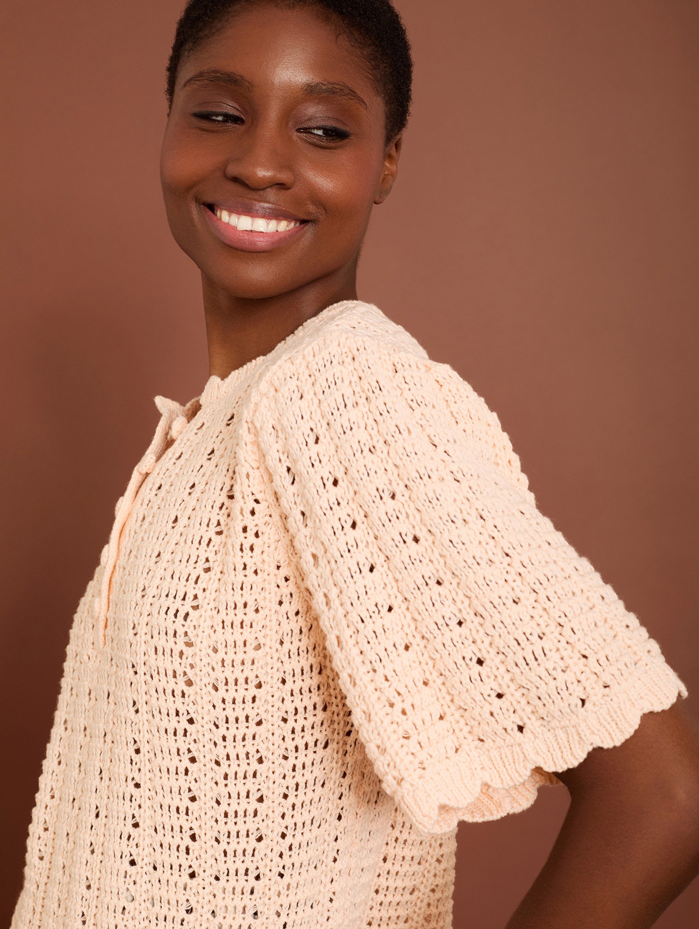 Crochet openwork jumper with ruffled sleeves and buttons